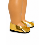 A close-up of a doll's legs wearing shiny gold ballet flats with a glittery bow and a clear rhinestone embellishment on the toe, set against a plain white background.