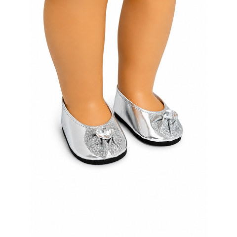 Silver metallic flats with glitter bow accents and clear crystal embellishments shown on an 18-inch doll.