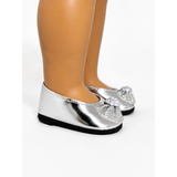 Silver metallic flat shoes with a rhinestone-embellished toe bow, shown on an 18-inch doll's legs against a white background.