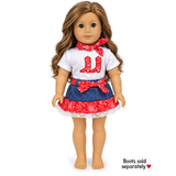 18-inch doll wearing a 3-piece red Western cowgirl outfit with white cowboy boot shirt, denim-look ruffled skirt and matching red bandana.